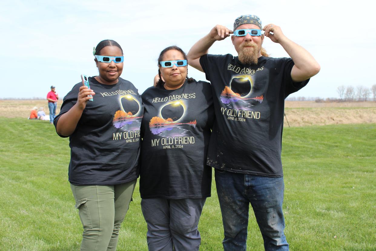 Wearing matching T-shirts with the saying, “Hello Darkness My Old Friend – April 8, 2024,” Brenna Coviak, left, with her parents, Kenya and Kyle Coviak, traveled from Warren to watch the solar eclipse at the Erie Marsh Preserve.