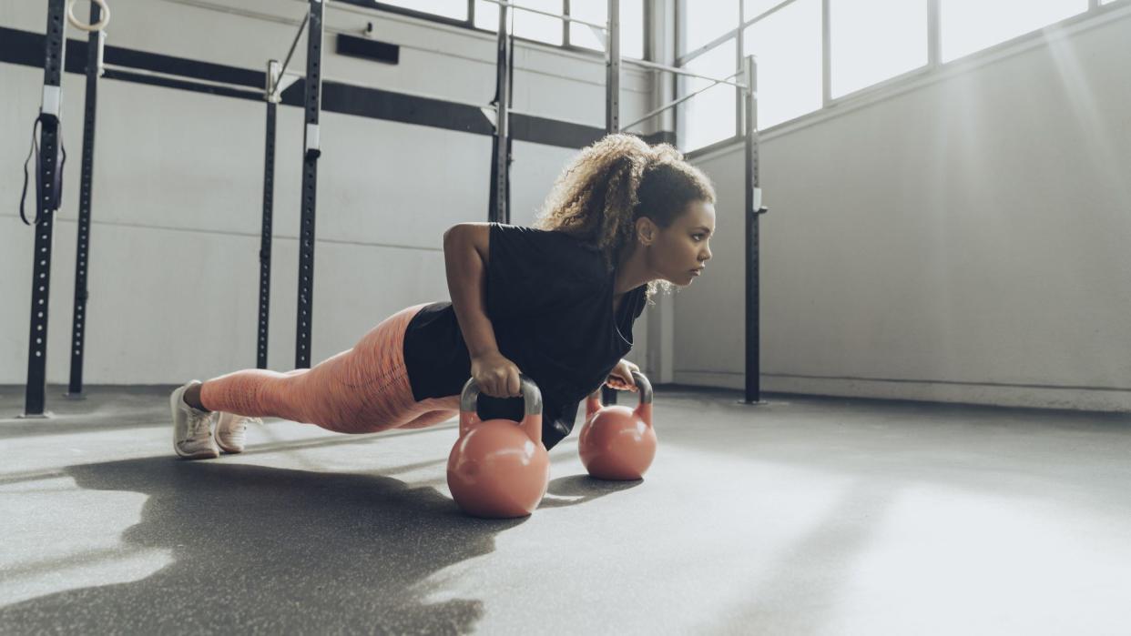 Woman does kettlebell workout. 