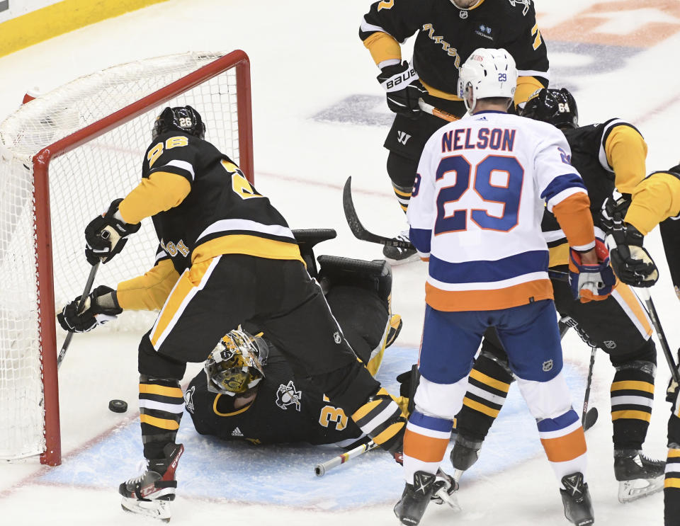 New York Islanders center Brock Nelson (29) watches the puck get by Pittsburgh Penguins goalie Tristan Jarry (35) and defenseman Jeff Petry (26) during the first period of an NHL hockey game, Thursday, March 9, 2023, in Pittsburgh. (AP Photo/Philip G. Pavely)