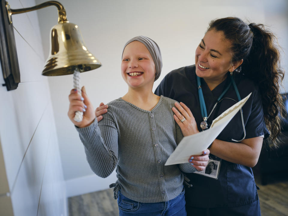 A young cancer patient smiling with a medical professional