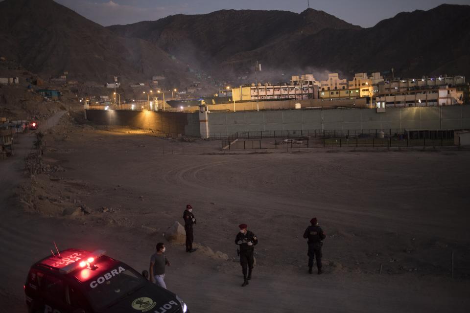 Police stand guard outside Castro Castro prison during a riot, in Lima, Peru, Monday, April 27, 2020. Peru's prison agency reported that three prisoners died from causes still under investigation after a riot at the Miguel Castro Castro prison in Lima. Inmates complain authorities are not doing enough to prevent the spread of coronavirus inside the prison. (AP Photo/Rodrigo Abd)