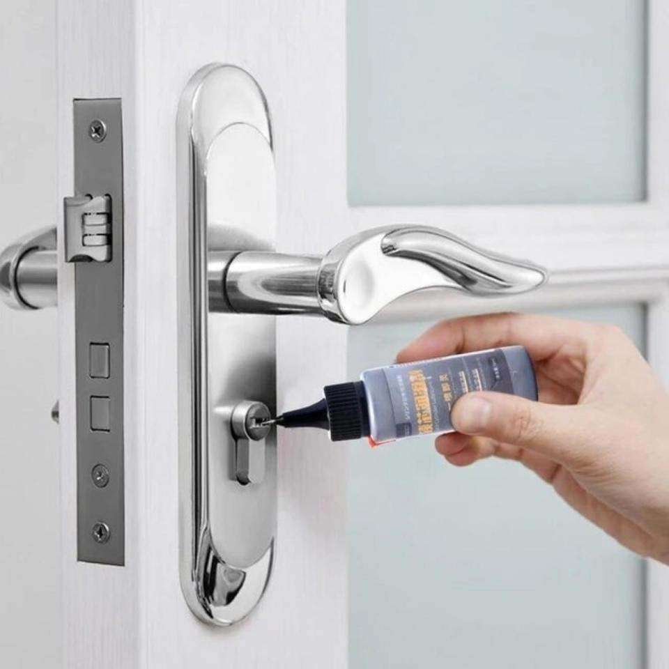 Using small bottle of lubricant to treat door lock.