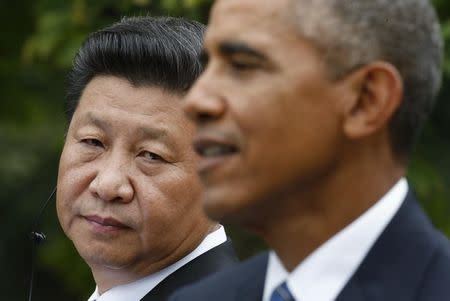 Chinese President Xi Jinping (L) listens to U.S. President Barack Obama during a joint news conference in the Rose Garden at the White House in Washington September 25, 2015. REUTERS/Kevin Lamarque