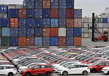 Renault cars produced in Turkey and awaiting export throughout Europe, are lined-up in front of ship containers in the port of Koper October 14, 2013. REUTERS/Srdjan Zivulovic