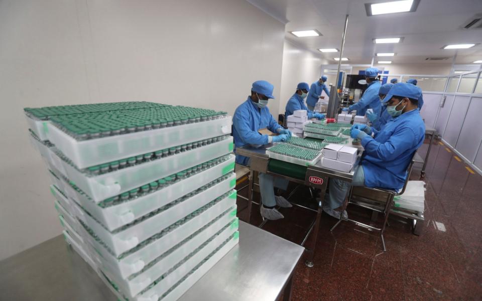 Employees pack boxes containing vials of AstraZeneca's COVISHIELD vaccine at the Serum Institute of India - Rafiq Maqbool /AP