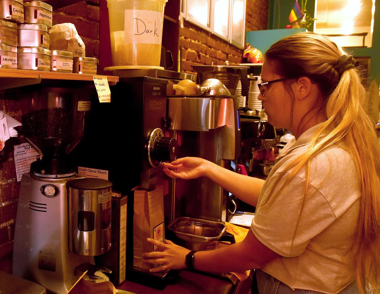 Katelyn Meyerpeter, a barista supervisor at Lakota Coffee Company at 24 S. Ninth St., grinds some hazelnut coffee beans for a customer in this 2021 photo.