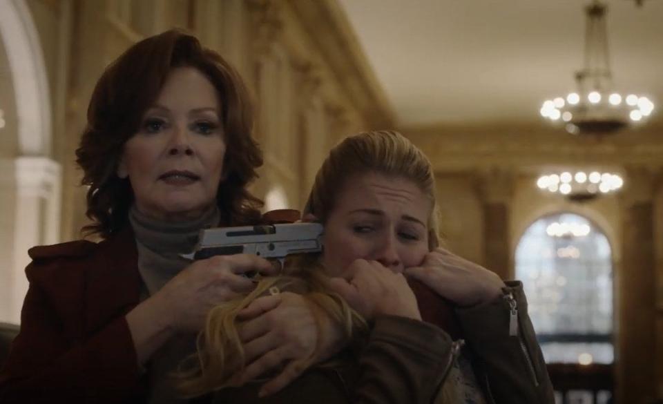 A woman (Jean Smart) holding someone hostage with a gun pointed at the temple of the hostage