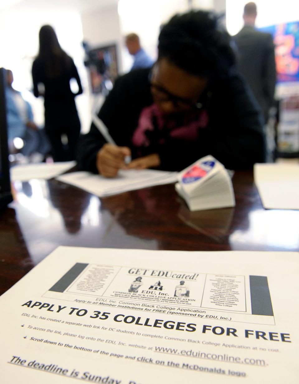 A high school student fills out a college application.