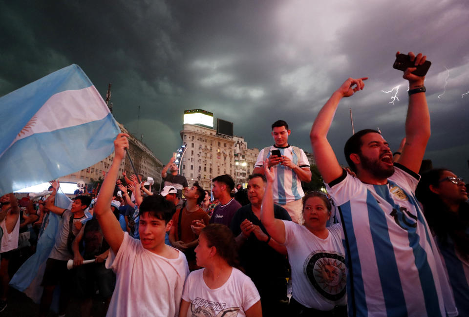 Soccer Football - FIFA World Cup Qatar 2022 - Fans in Buenos Aires watch Netherlands v Argentina - Buenos Aires, Argentina - December 9, 2022 Argentina fans in Buenos Aires celebrate qualifying for the Semi Finals as lightning strikes in the background REUTERS/Agustin Marcarian