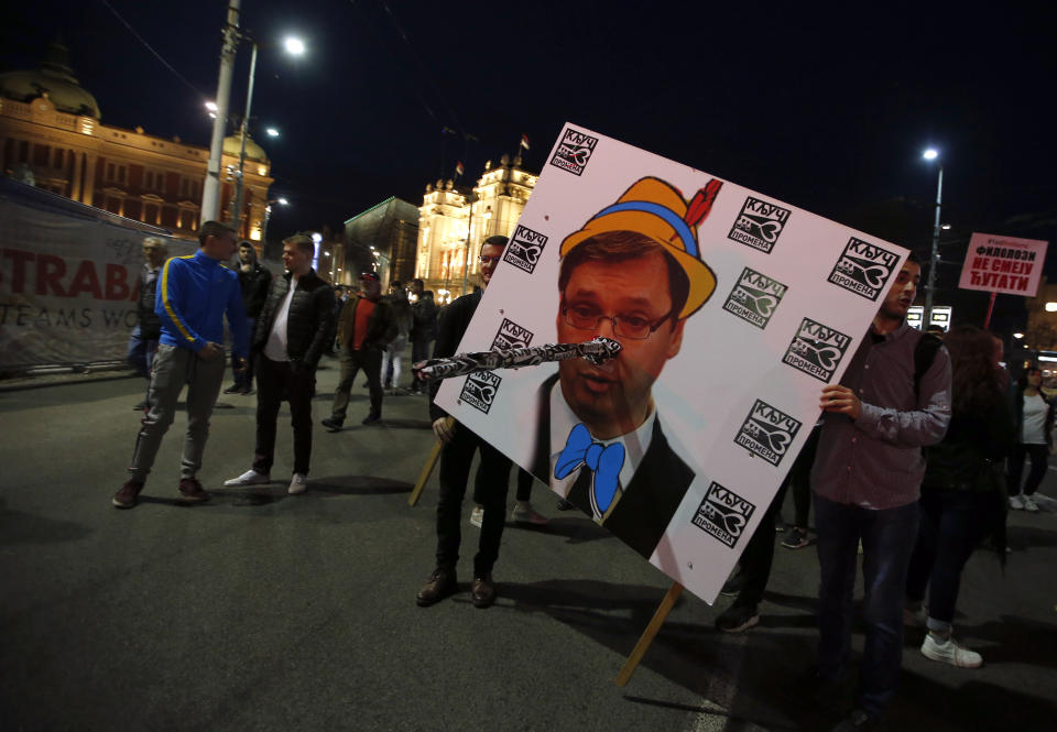 People hold a poster of populist President Aleksandar Vucic depicted as the character Pinocchio during a protest in Belgrade, Serbia, Saturday, March 9, 2019. The demonstrations in Serbia have lasted for three months seeking more democracy in the Balkan country that is firmly under control of the populist leader Aleksandar Vucic. (AP Photo/Darko Vojinovic)
