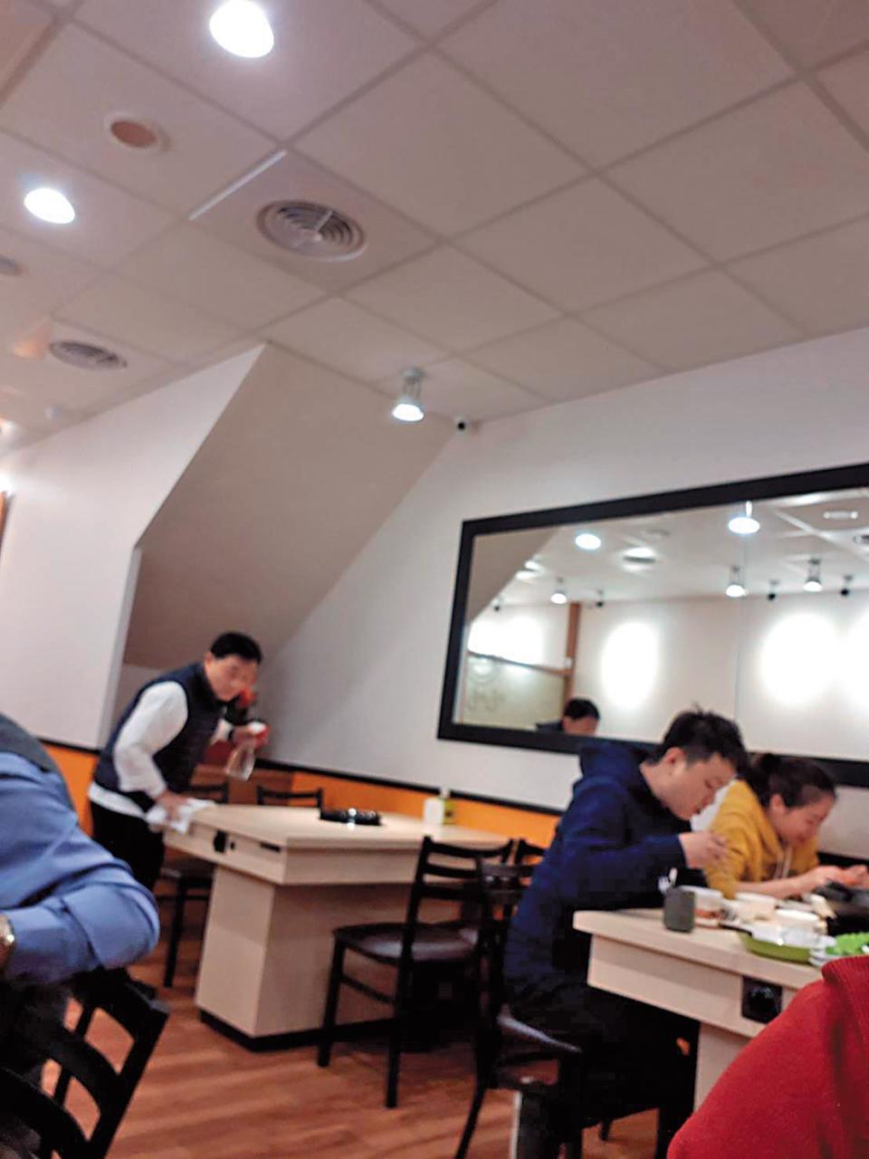 阿基師出現在台北市一間石頭火鍋店，忙著擦桌子整理店內環境。（讀者提供）