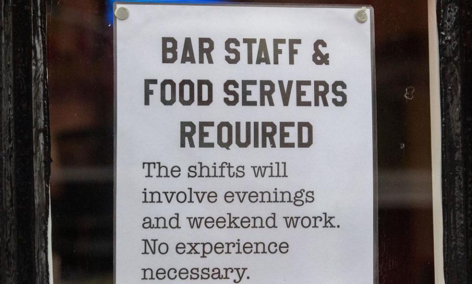 sign in a window saying bar staff and food servers required