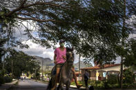 A man rides his horse through Viñales, Cuba, March 1, 2021. Both U.S. sanctions meant to punish the government and a COVID-19 pandemic have squashed tourism almost everywhere, making some Cubans hope that new U.S. President Joe Biden will reverse at least some of the restrictions implemented by his predecessor. (AP Photo/Ramon Espinosa)