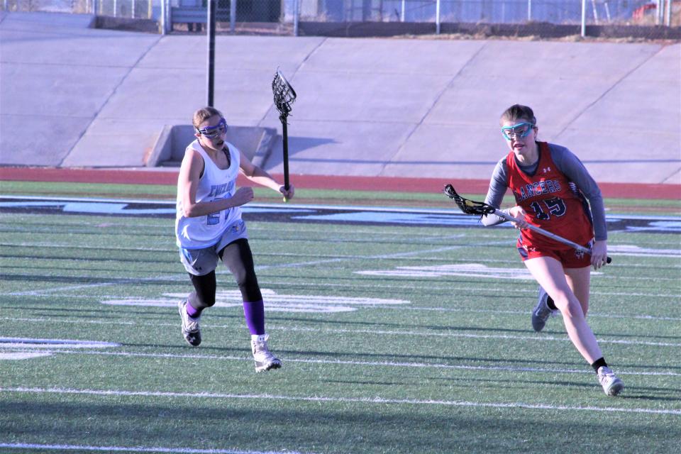 Dory Dugal (#27) for Pueblo West chases down Summer Owen (#15) of Liberty High School during a match-up on April 7, 2022.