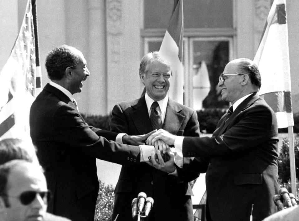 Egyptian President Anwar Sadat, left, U.S. President Jimmy Carter, center,  and Israeli Prime Minister Menachem Begin clasp hands on the north lawn of the White House after signing the peace treaty between Egypt and Israel on March 26, 1979. Sadat and Begin were awarded the Nobel Peace Prize for accomplishing peace negotiations in 1978.