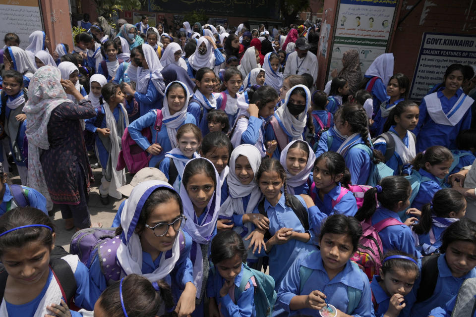 Students leave after attending their school as authorities announced reduced school hours due to soaring temperature, in Lahore, Pakistan, Tuesday, May 21, 2024. Authorities in Pakistan on Tuesday urged people to stay indoors as the country is hit by an extreme heat wave that threatens to bring dangerously high temperatures and yet another round of glacial-driven floods. (AP Photo/K.M. Chaudary)