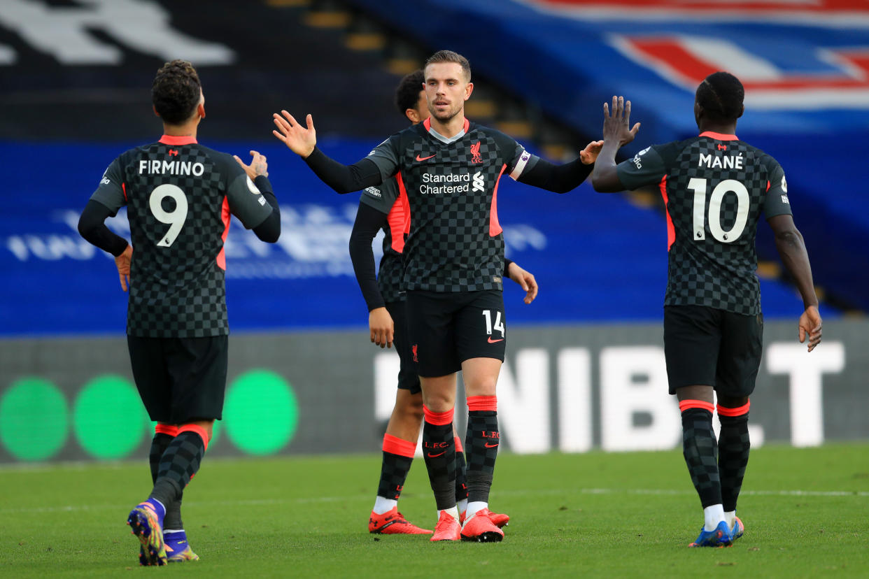 Liverpool captain Jordan Henderson (centre) celebrates with teammates Sadio Mane (right) and Roberto Firminho after scoring against Crystal Palace.