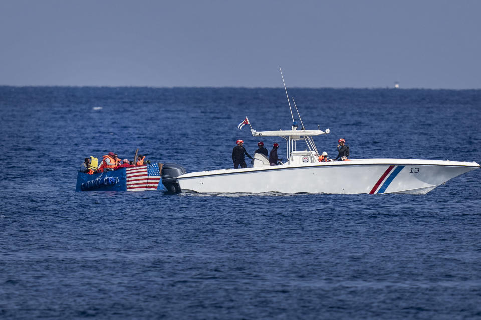 People in a makeshift boat with the U.S. flag painted on the side are captured by the Cuban Coast Guard near the Malecon seawall in Havana, Cuba, Monday, Dec. 12, 2022. (AP Photo/Ramon Espinosa)