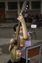 In this Dec. 11, 2012 photo, Noelia Rios, 12, tunes her guitar made of recycled materials as she practices with “The Orchestra of Instruments Recycled From Cateura” in Cateura, a vast landfill outside Paraguay's capital of Asuncion, Paraguay. Children use instruments fashioned out of recycled materials taken from a landfill where their parents eke out livings as trash-pickers, and about 20 of them regularly perform the music of Beethoven and Mozart, Henry Mancini and the Beatles. Noelia's 14-year-old sister and 16-year-old aunt also play in the orchestra. (AP Photo/Jorge Saenz)