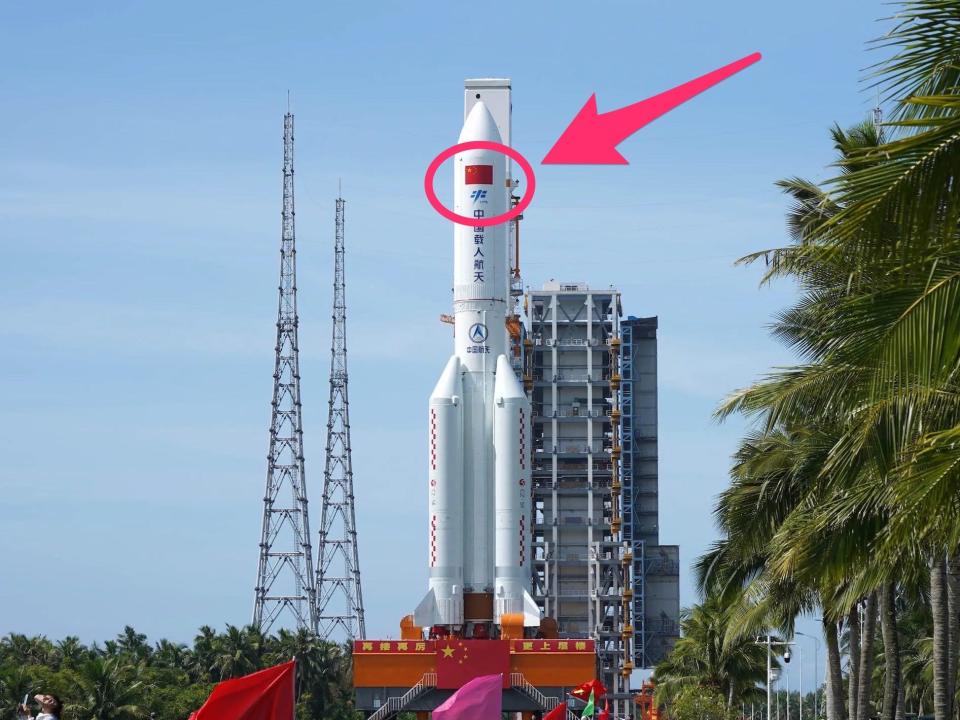large white rocket with arrow pointing to red Chinese flag and blue Chinese space agency symbol