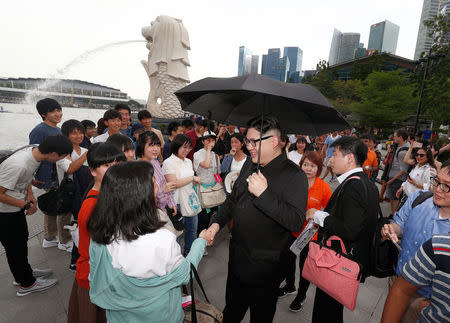 Howard, an Australian-Chinese impersonating North Korean leader Kim Jong Un, talks to South Korean students at the Merlion Park in Singapore May 27, 2018. REUTERS/Edgar Su