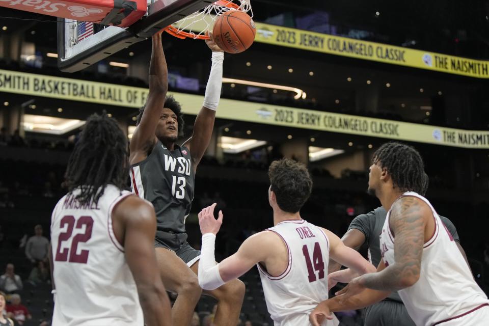 Washington State forward Isaac Jones (13) dunks over Santa Clara guard Carlos Marshall Jr. (22) and forward Johnny O’Neil (14) during the second half of an NCAA college basketball game, Saturday, Dec. 16, 2023, in Phoenix. | Rick Scuteri, Associated Press