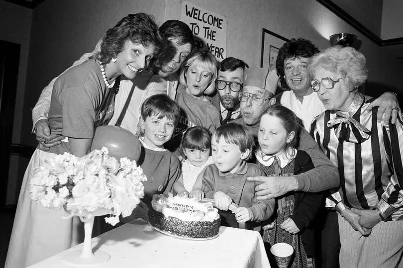Party organised by The Liverpool Echo and Gold Crown Foods Ltd, who own Mantunna Tea, and held for 100 Merseyside people born on the 29th February, who only truly celebrate their birthdays once every four years. Picture shows "one year olds" Emma and Paul Davison and "two year olds" Elizabeth and Nicholas Parkes put out the cake candles watched by DJ Billy Butler, Wally Scott, Emma, and Echo marketing editor Arthur Johnson (centre). February 29, 1988