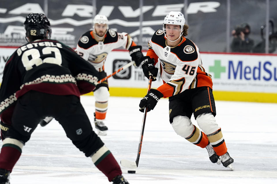 Anaheim Ducks center Trevor Zegras (46) carries the puck in front of Arizona Coyotes defenseman Jordan Oesterle (82) in the first period during an NHL hockey game, Monday, Feb. 22, 2021, in Glendale, Ariz. (AP Photo/Rick Scuteri)