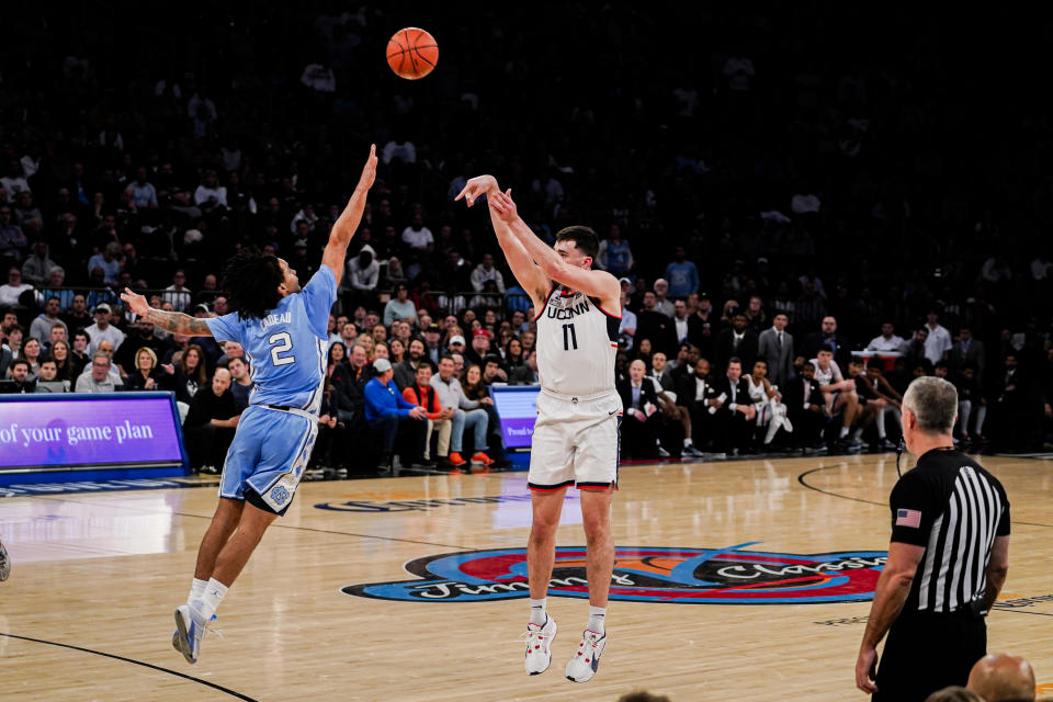 UConn forward Alex Karaban (11) shoots the ball over North Carolina guard Elliot Cadeau (2) during the first half of an NCAA college basketball game in New York, Tuesday, Dec. 5, 2023. (AP Photo/Peter K. Afriyie)