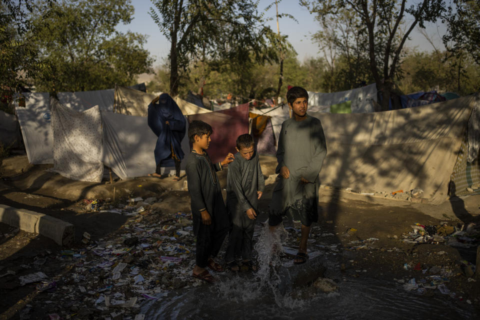 Afghan children wash their feet in a fountain at an internally displaced persons camp in Kabul, Afghanistan, Monday, Sept. 13, 2021. (AP Photo/Bernat Armangue)