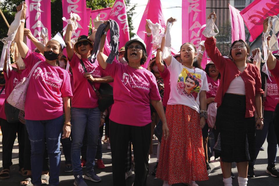 Women activists raise bras to symbolize their breaking free from restrictions imposed on them as they join an International Women's Day protest in Manila, Philippines on Friday March 8, 2024. (AP Photo/Aaron Favila) Favila)