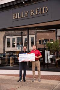 Billy Reid (left) presents a $27,548 donation to Wounded Warriors Family Support Development Director Kevin Sander.