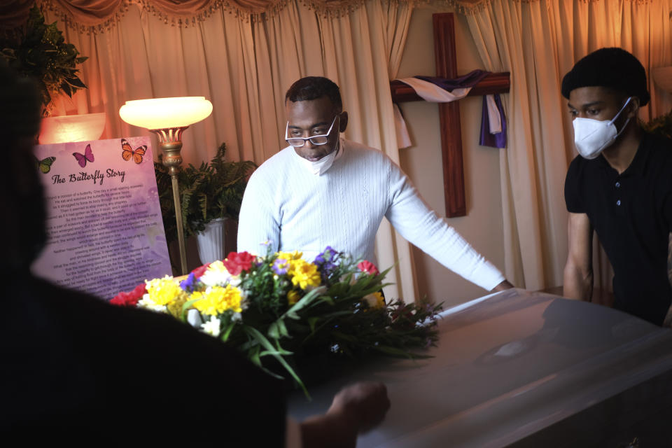 Kenneth Cattenhead, director ejecutivo de la funeraria The Family, ayuda a transportar un féretro el jueves 30 de abril de 2020 hasta una carroza en Newark, Nueva Jersey. Las familias han tenido que honrar a sus muertos a distancia y en pequeños grupos durante los tiempos actuales de distanciamiento social. (AP Foto/Seth Wenig)