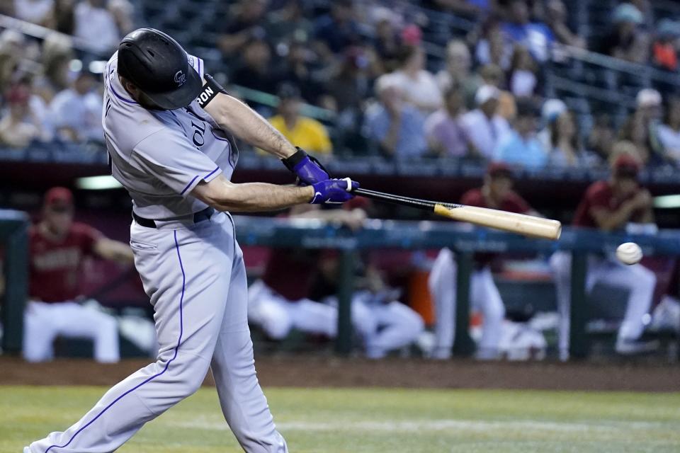 Colorado Rockies' C.J. Cron connects for a two-run double against the Arizona Diamondbacks during the sixth inning of a baseball game Sunday, Aug. 7, 2022, in Phoenix. (AP Photo/Ross D. Franklin)