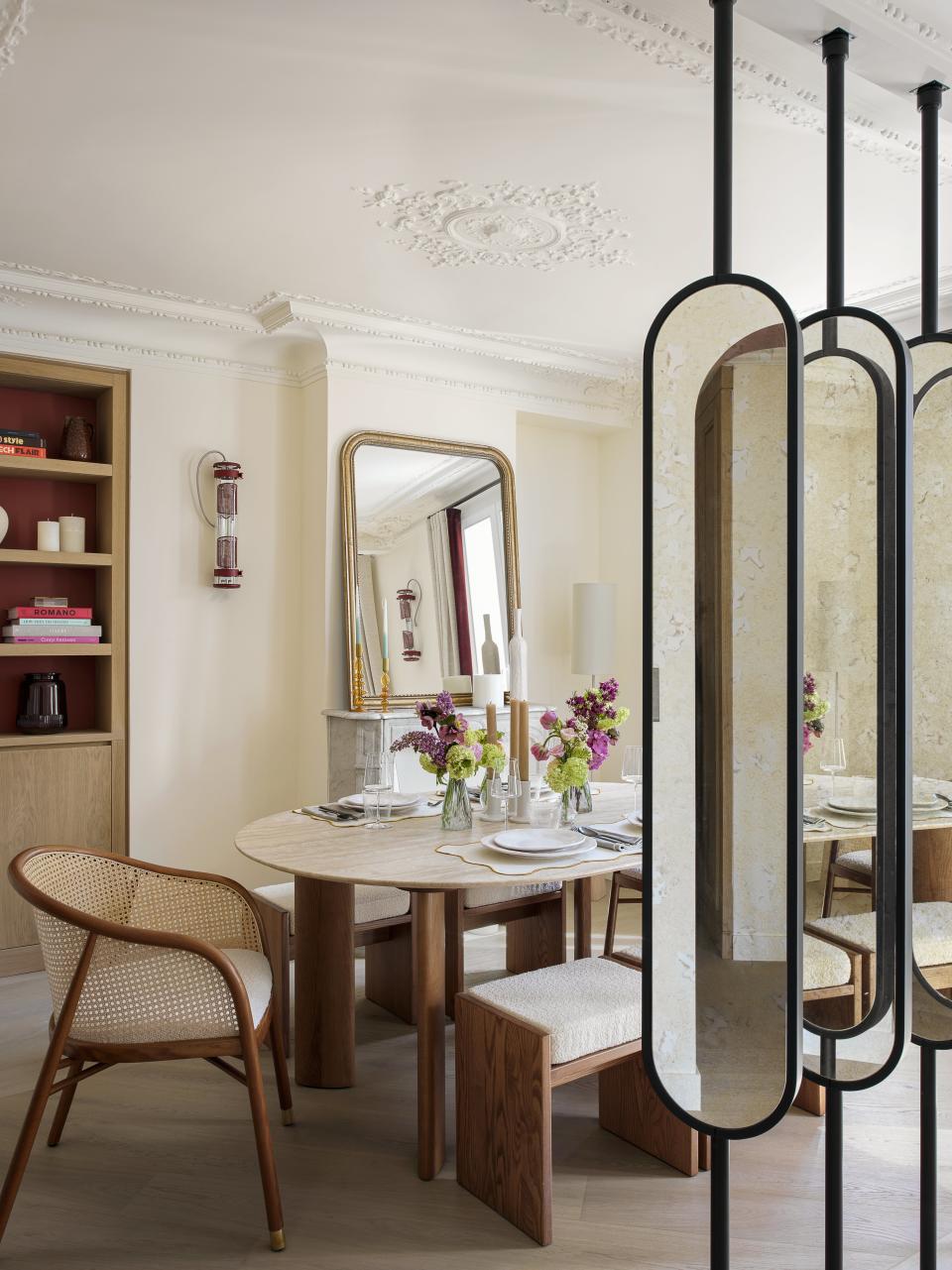 A living room with mirror panels as an architectural feature in the middle of the room