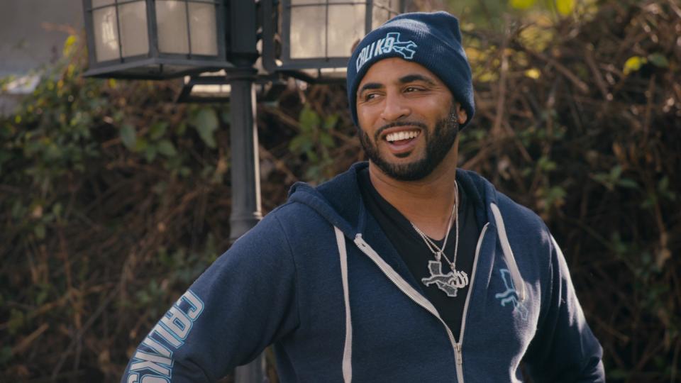 "Canine Intervention" star and dog trainer Jas Leverette smiling in a blue Cali K9 hoodie and beanie.