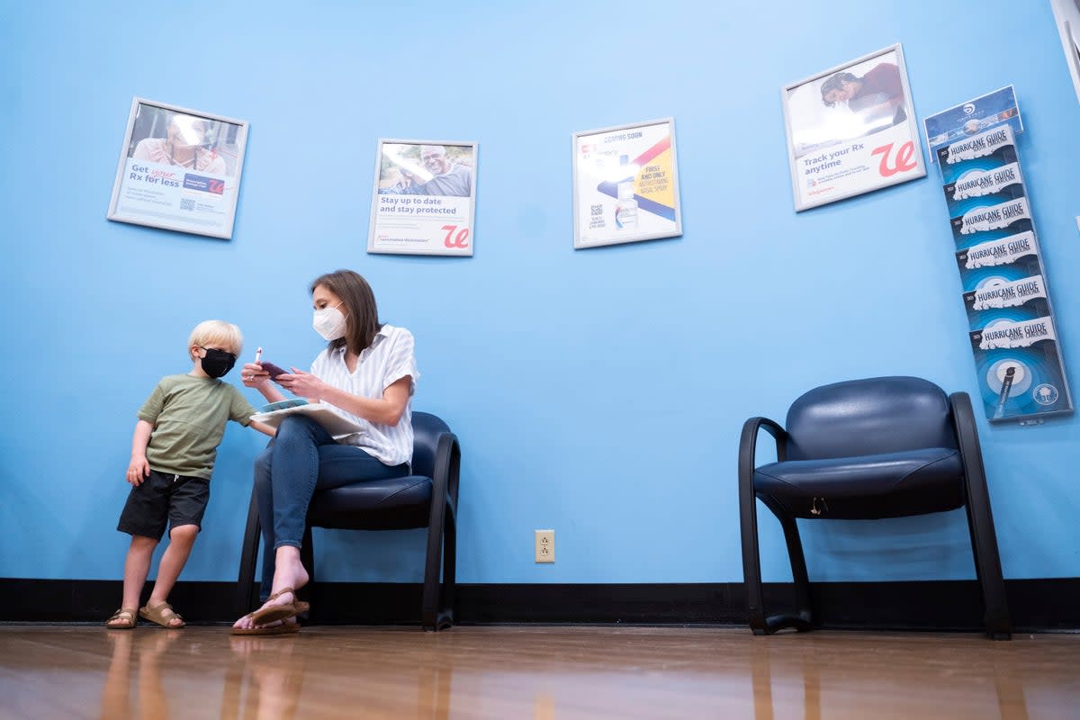 Three year-old Fletcher Pack watches as his mother, McKenzie Pack, fills out paperwork prior to receiving the Moderna Covid-19 vaccination in Lexington, South Carolina  (Copyright 2022 The Associated Press. All rights reserved.)