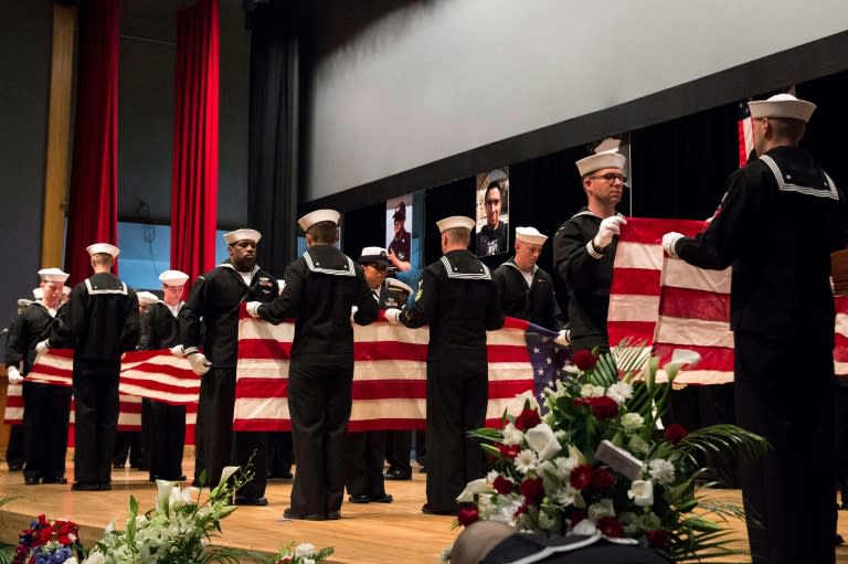 US sailors ceremonially fold seven US flags during a memorial ceremony for the sailors killed in a collision with between a US destroyer and Philippine cargo ship this month