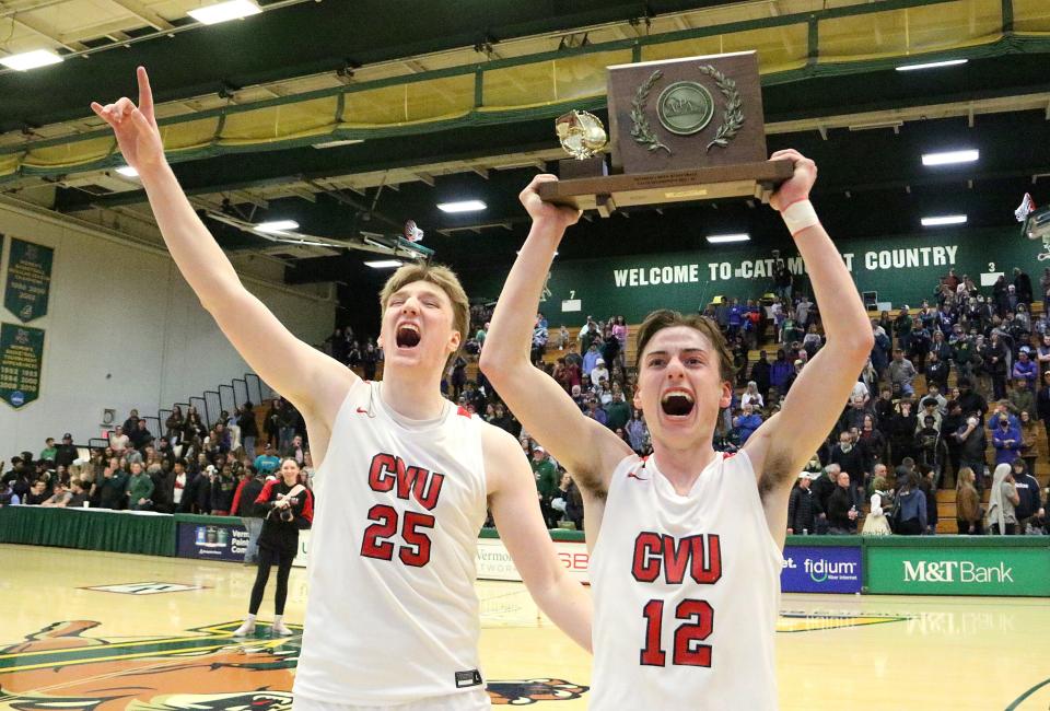 Senior captain's Logan Vaughan (25) and Alex Provost (12) bring the trophy to their teammates after the Redhawks defeated Rice 42-38 to claim the D1 title at Patrick gym on Saturday night.