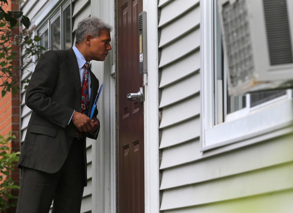 Rochester School District Superintendent Bolgen Vargas approaches an apartment building during a recent attendance blitz, where he and others visited the homes of chronically absent students to help alert families of resources that may help prevent kids from missing school.