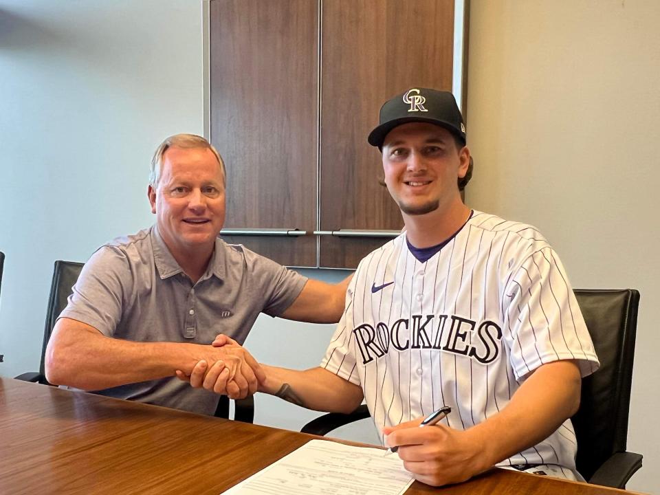 Kent State first baseman and Massillon product Aidan Longwell (right) signs with the Colorado Rockies. At left is the Rockies' senior director of scouting operations, Marc Gustafson.