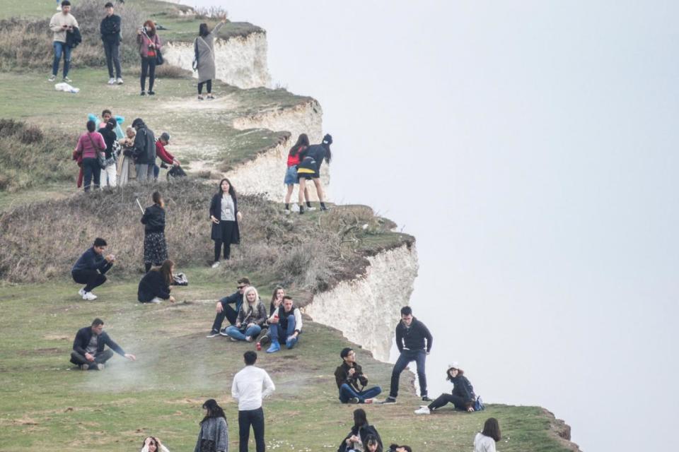 The woman peers over the edge with a friend (Alamy Live News)