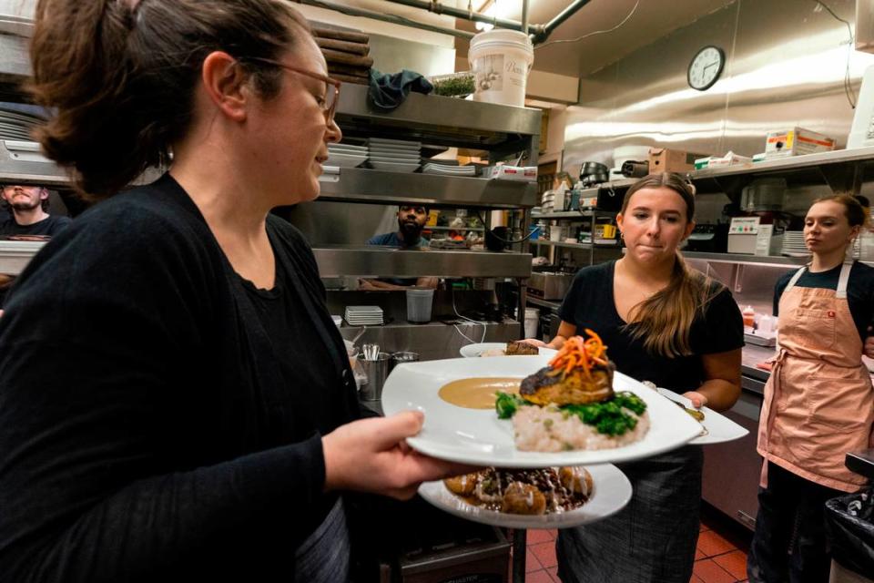 Jessica Lagomarsine, left, trains Katie Benesh on her first night working at Saluda’s Restaurant in Columbia’s Five Points.