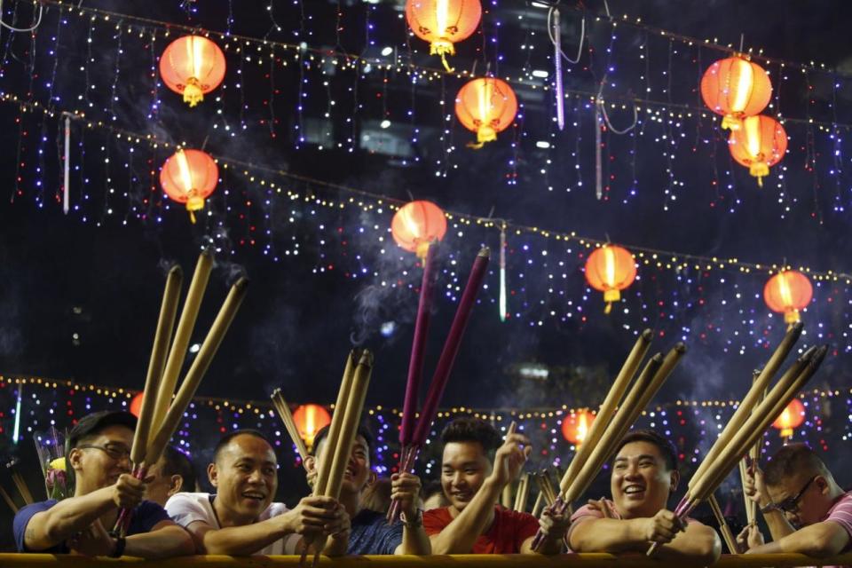 People wait to plant the first joss stick of the Lunar New Year of the Monkey at the stroke of midnight at the Kwan Im Thong Hood Cho temple on 7 February. Photo: Reuters/Edgar Su.