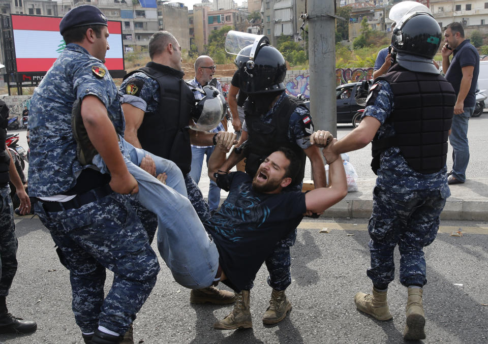 Police remove anti-government protesters blocking a main highway in Beirut, Lebanon, Saturday, Oct. 26, 2019. The removal of the roadblocks on Saturday comes on the tenth day of protests in which protesters have called for civil disobedience until the government steps down. (AP Photo/Hussein Malla)