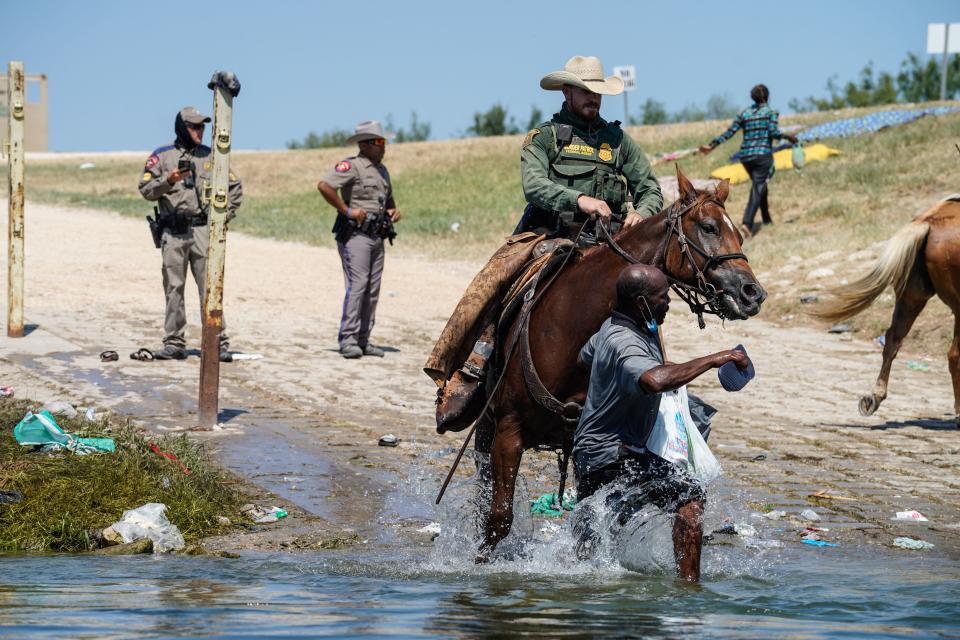 A United States Border Patrol agent on horseback tries to stop a Haitian migrant from entering an encampment on the banks of the Rio Grande near the Acuna Del Rio International Bridge in Del Rio, Texas on 19 September 2021 (AFP via Getty Images)