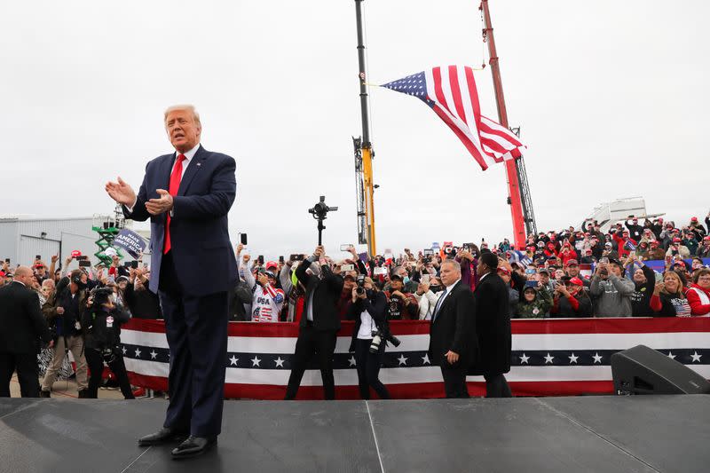 U.S. President Donald Trump applauds during a campaign event at MBS International Airport, in Freeland