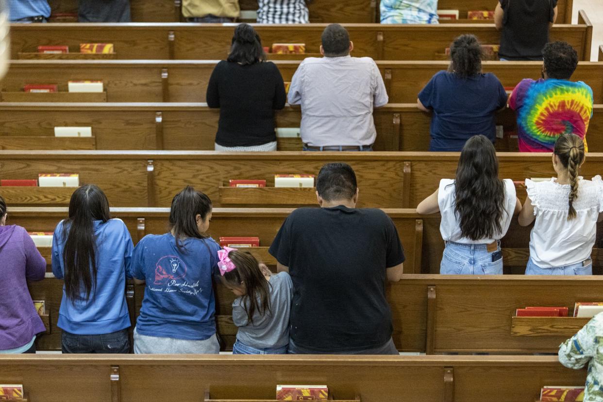 People pray at Sacred Heart Church Tuesday evening, May 24, 2022, in Uvalde, Texas after a gunman earlier in the day entered Robb Elementary School and killed multiple children and adults.