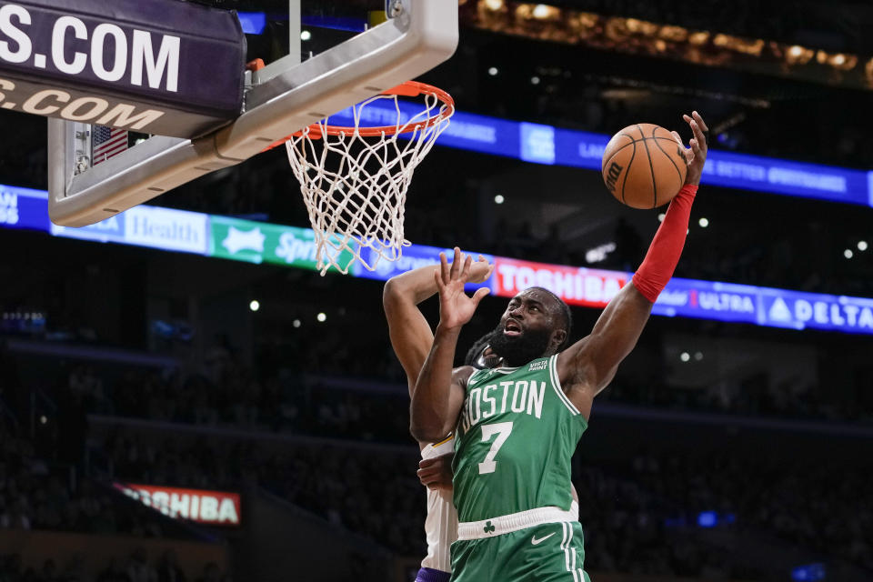 Boston Celtics guard Jaylen Brown (7) attempts to dunk past Los Angeles Lakers forward Rui Hachimura during the first half of an NBA basketball game, Monday, Dec. 25, 2023, in Los Angeles. (AP Photo/Ryan Sun)