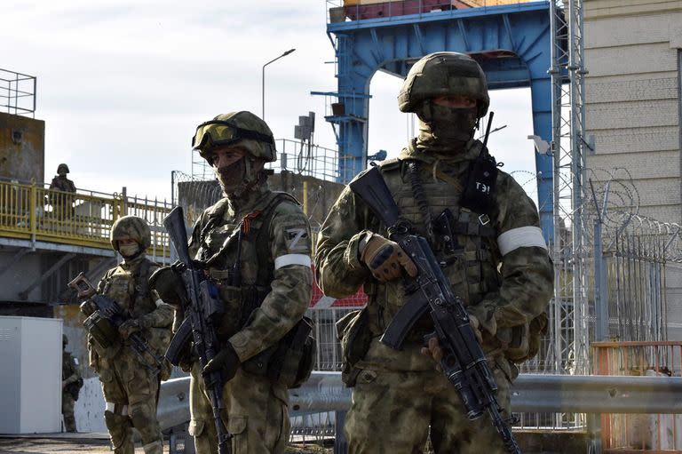 En esta foto de archivo tomada el 20 de mayo de 2022, militares rusos patrullan en la central hidroeléctrica de Kakhovka, en el óblast de Kherson, en medio de la actual acción militar rusa en Ucrania